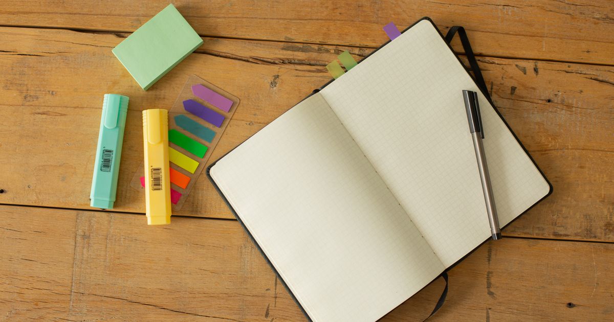 An open notebook with a pen resting on a blank page